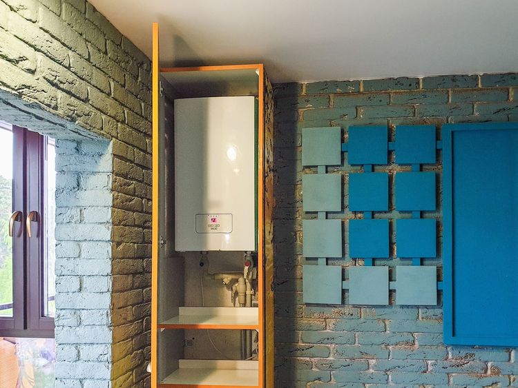 Wall-mounted electric geyser in a cupboard